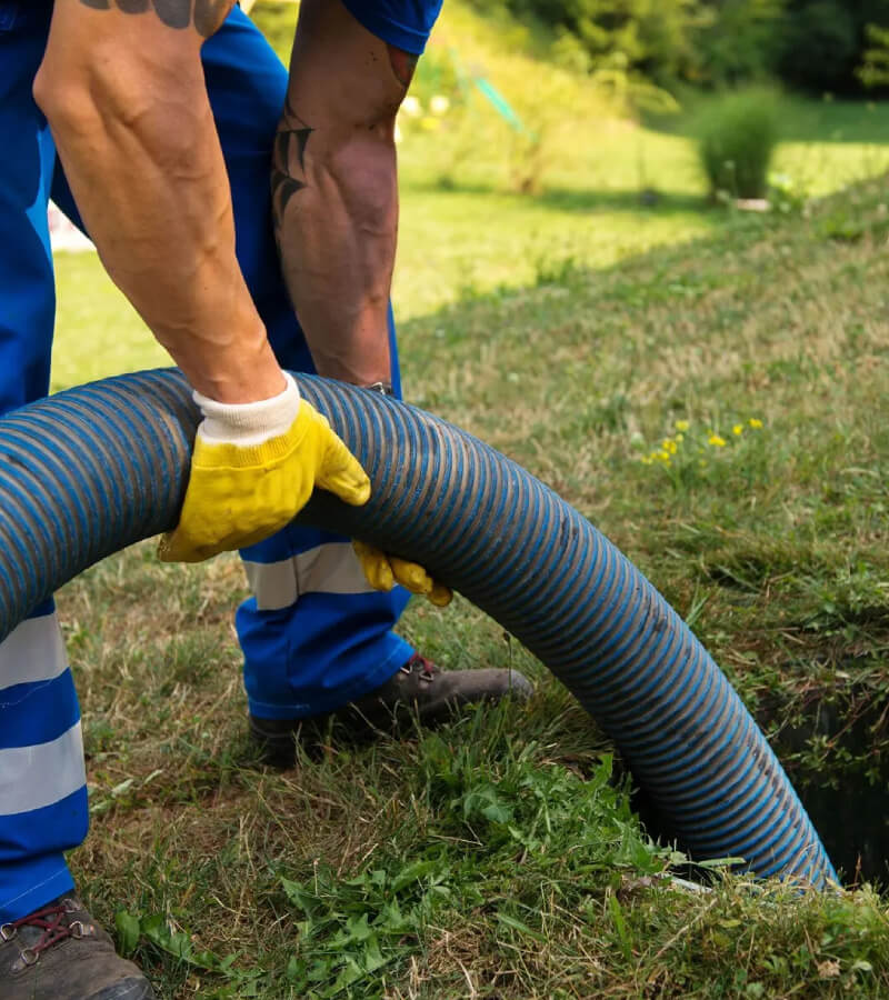 A drain pipe being placed into a drainage hole