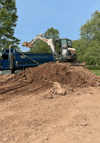 An excavator and a dump truck moving dirt